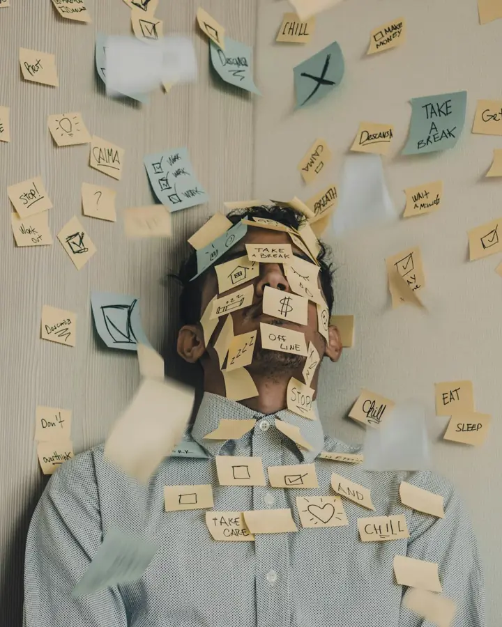 A man at his desk covered in sticky notes